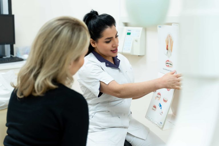 Mondhygiënist geeft uitleg aan de hand van een gebitsposter